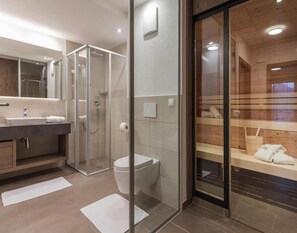 Enjoy a spa-like experience in this bathroom with a walk-in shower, contemporary sink, and wooden bench.