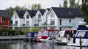 Una hilera de casas modernas con un barco amarrado al frente.