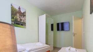 A hotel room with two beds, a television, and a wardrobe. - Ferienwohnung Schlossblick, Wernigerode (Wernigerode)