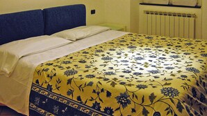 A bed with a floral bedspread and a blue headboard. - Apartment in Mongelia (Moneglia)