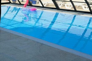 A swimming pool with a clear blue water surface, a pink flamingo float, and a tiled floor. - Comfortable, Two-story Holiday Home, Summer Pool (Postomino)