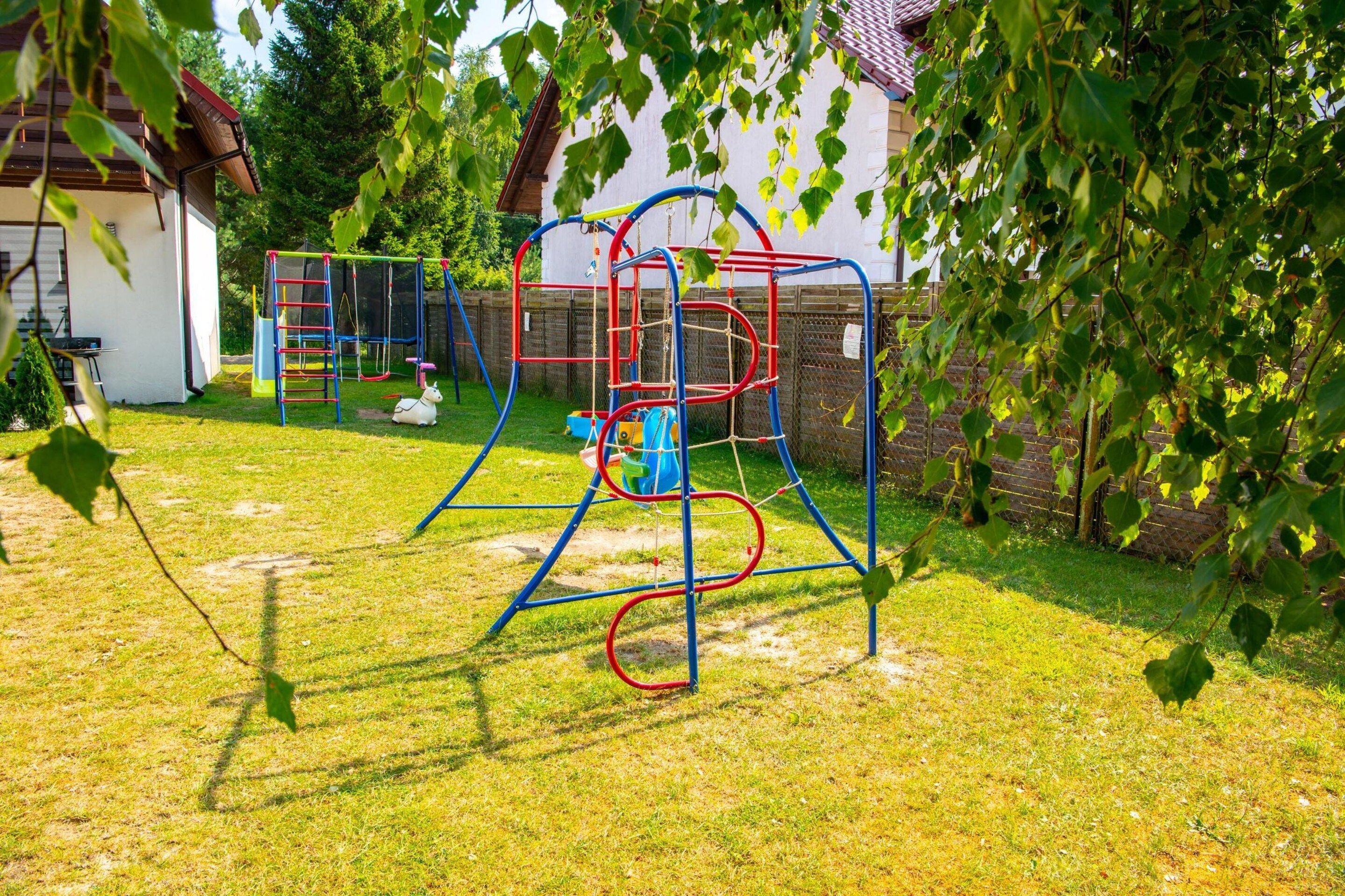 A playground with a swing set, climbing frame, and slides.