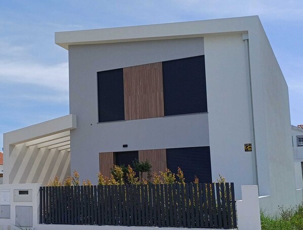 Un bâtiment moderne à deux étages, doté d’un toit plat, de grandes fenêtres et d’un revêtement mural en bois.
