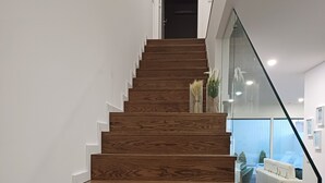 Een moderne trap met houten treden en een glazen balustrade.