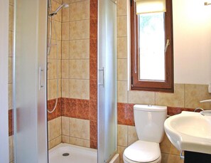 Ein Badezimmer mit Dusche, Toilette und Waschbecken.