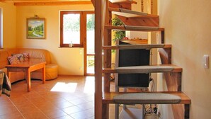 A wooden staircase with a cushioned landing, a sofa, and a painting on the wall. - Holiday Home by Lake Wilkasy With Rowboat (Gizycko)