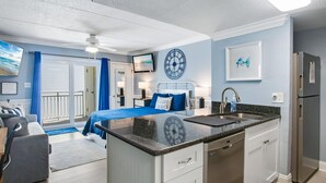 A modern kitchen with a central island, a built-in dishwasher, and a refrigerator.