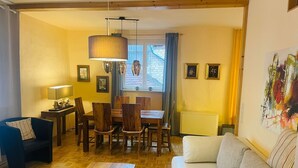 A cozy living room with a sofa, a wooden coffee table, and a dining area with a table and chairs. - Apartments Am Untertor, Meersburg (Meersburg)