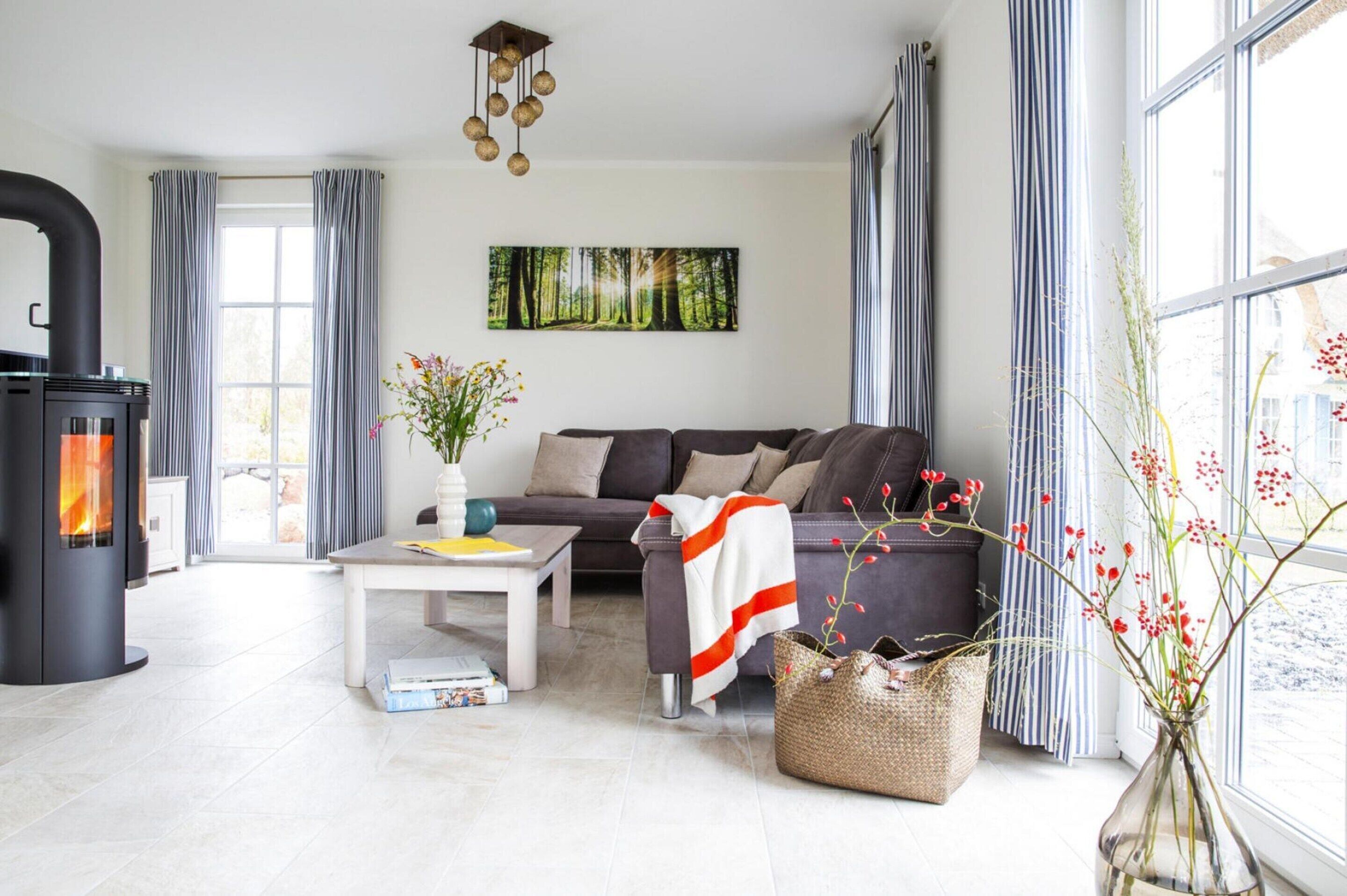 A modern living room with a fireplace, a sofa, a coffee table, and a large window with curtains.
