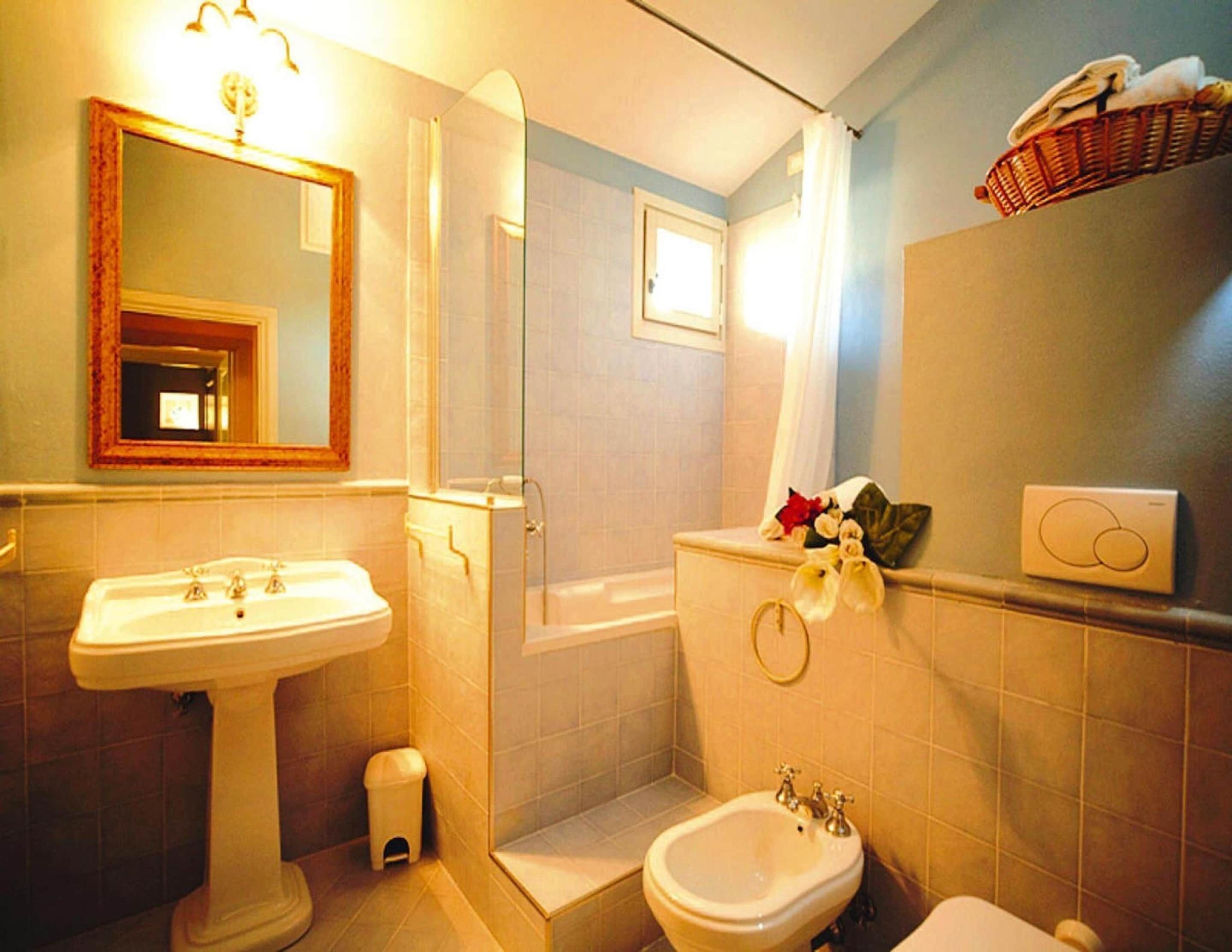 A bathroom with a pedestal sink, a bathtub, a shower, and a bidet.
