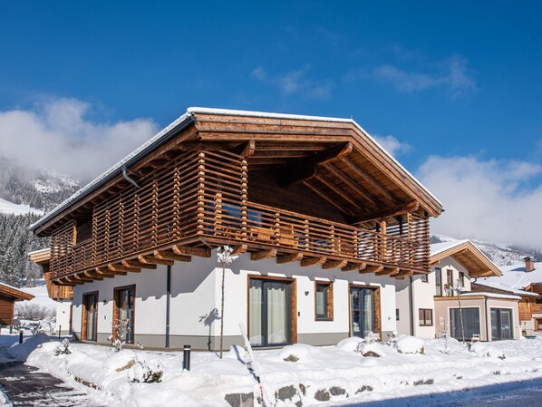 A modern chalet with a wooden balcony, white exterior, and snow-covered surroundings. - Chalet in Wald Near Krimml Waterfalls (Wald im Pinzgau)