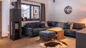 A modern living room with a sectional sofa, a wooden coffee table, and a fur rug. - Chalet in Wald Near Krimml Waterfalls (Wald im Pinzgau)