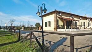 Un edificio con un cartello che riporta la scritta "B&B Poste" e un'area pavimentata delimitata da una recinzione.