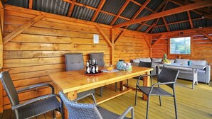 Un interior de madera con techo alto, una mesa de madera con sillas y un sofá.