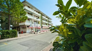 A multi-story hotel with balconies, a visible storefront, and a clear sky. - Apartments Condominio Diana, Bibione Lido del Sole-formerly TUI Ferienhaus (San Michele al Tagliamento)