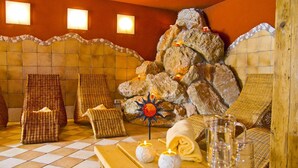 Ein Spa-Raum mit Steinwand, Korbmöbeln und Kerzen.