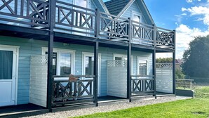 Une maison à deux étages dotée d’un balcon et d’un porche abrité.