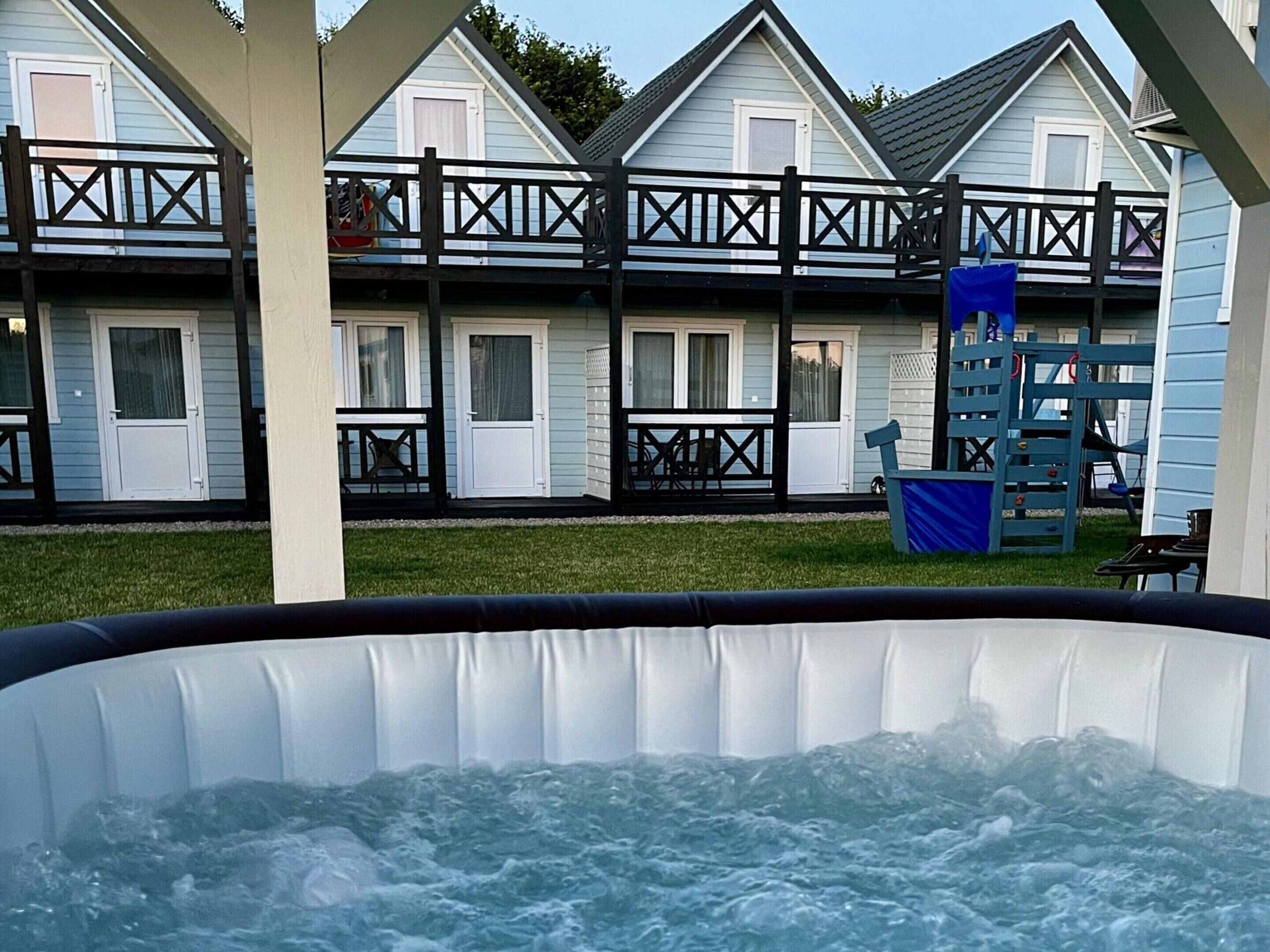 Un jacuzzi frente a una hilera de casas de dos pisos con balcones.