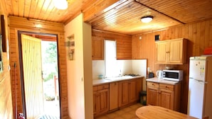 Une cuisine compacte avec des meubles en bois, un four à micro-ondes et un réfrigérateur.