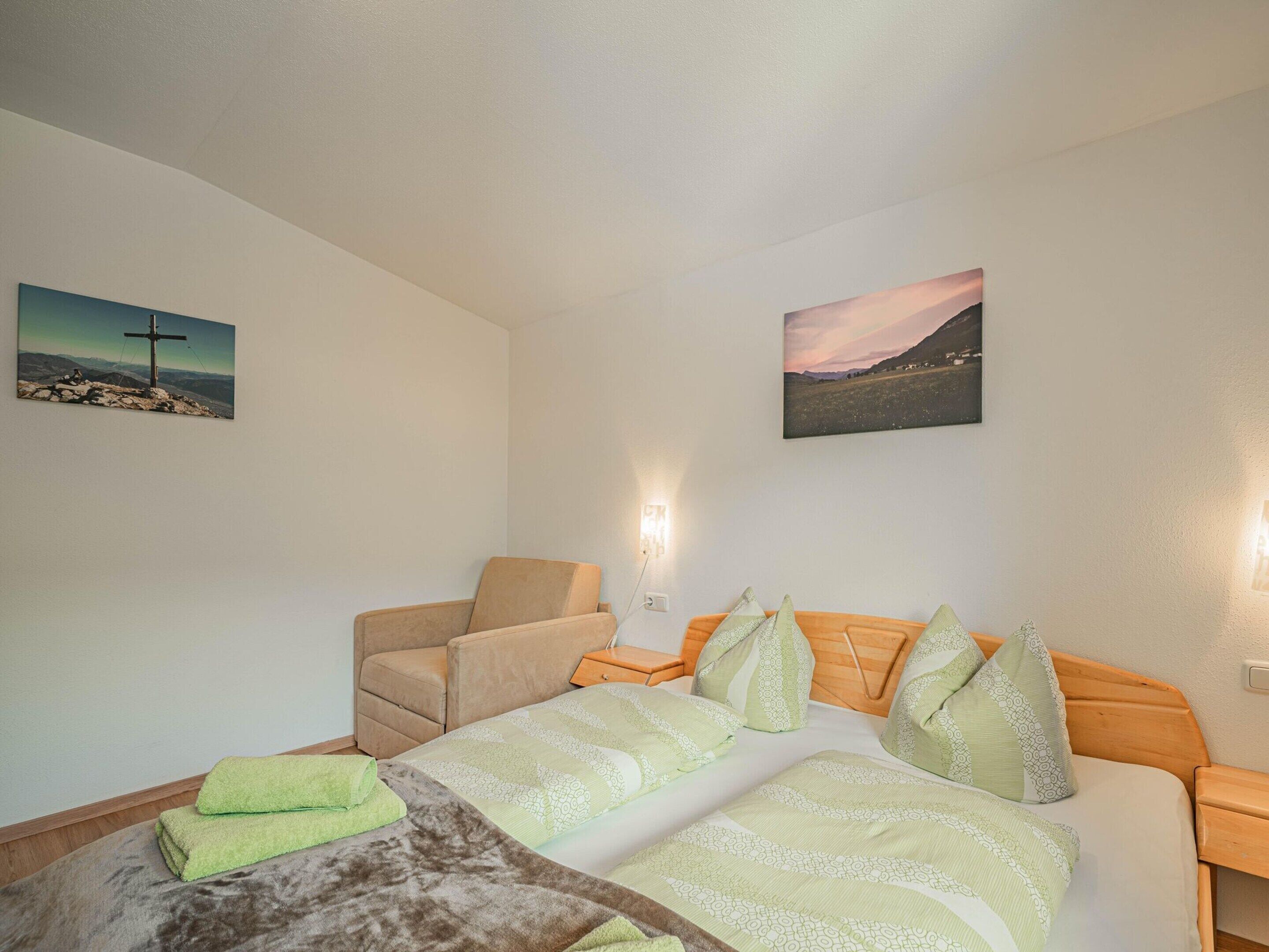 Ein Schlafzimmer mit einem Bett, einem Sessel und zwei Wandleuchten.