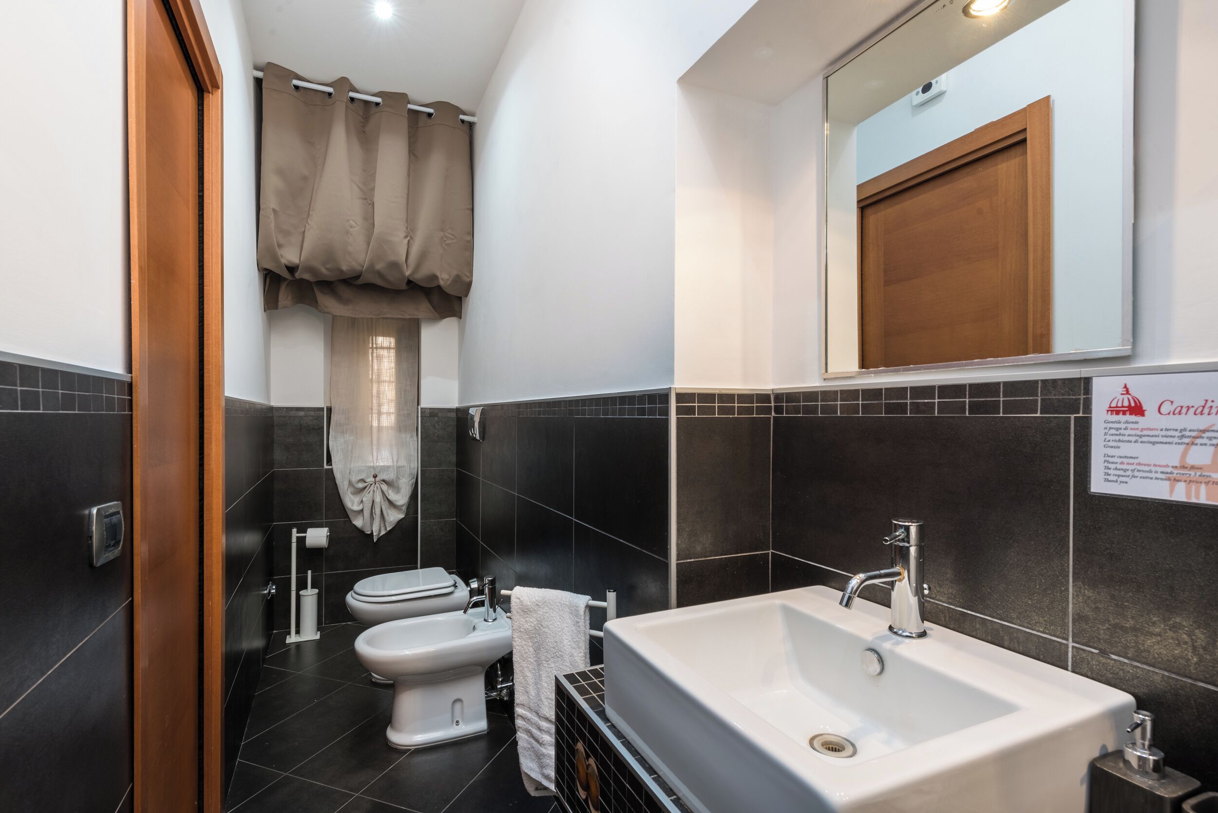 A modern bathroom with a white sink, a bidet, and a toilet.