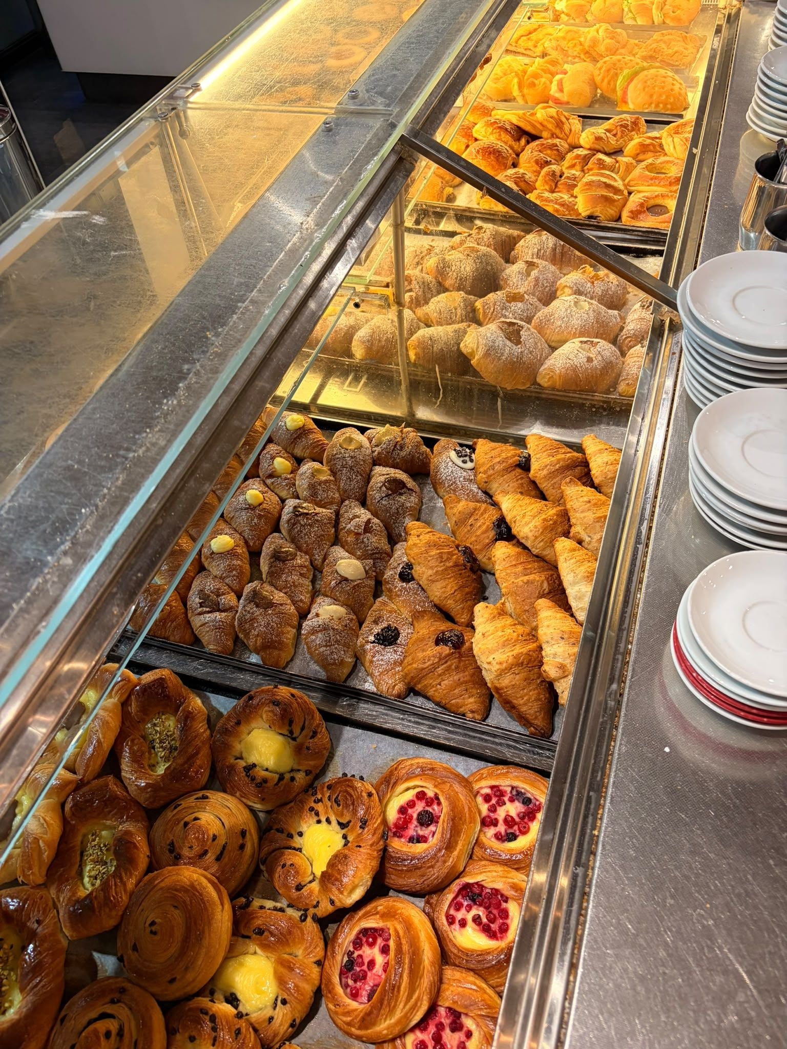 A bakery display case with various pastries and bread.