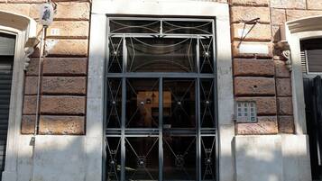 Eine Gebäudefassade mit einem großen Bogenfenster, das aufwendete Metallarbeiten zeigt.