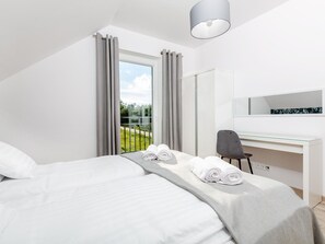 A modern hotel room with a bed, a desk, and a large window with curtains. - Comfortable Holiday Complex in Jastrzebia Gora (Wladyslawowo)