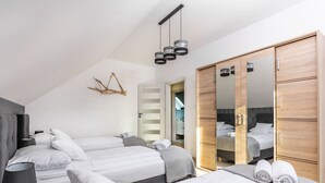 Une chambre d’hôtel moderne avec deux lits, une armoire et un miroir.