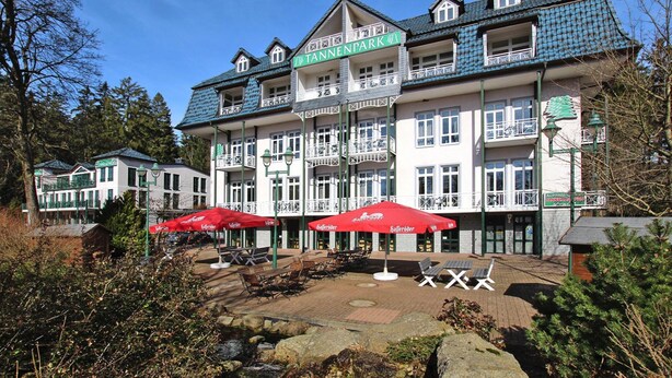 Un hotel Tannenpark con asientos exteriores y un patio de piedra.