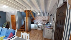 Ein kompakter Wohnbereich mit Küche, Essbereich und einer Treppe, die in eine obere Etage führt.