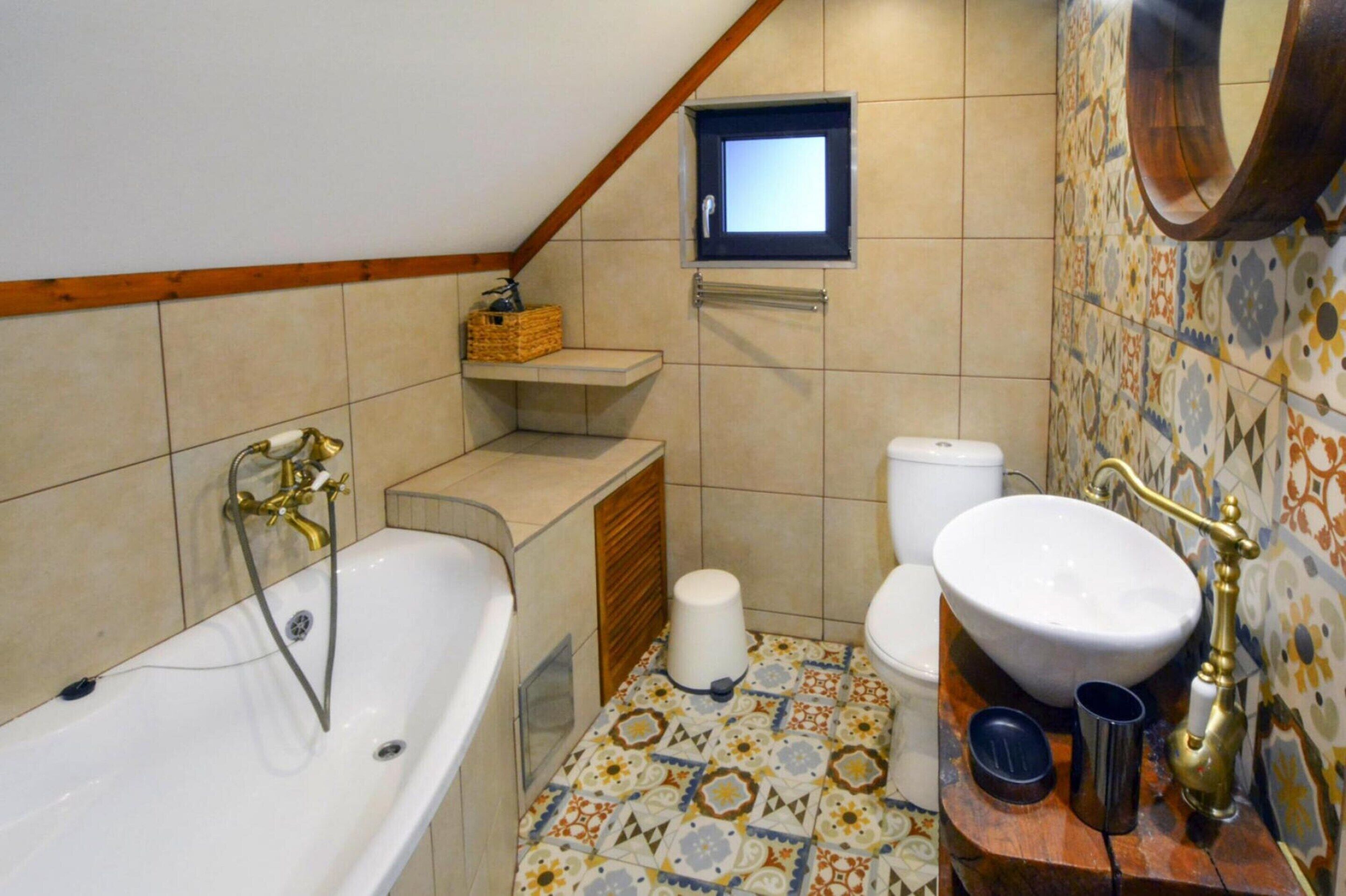 Een badkamer met een bad, toilet en wastafel.