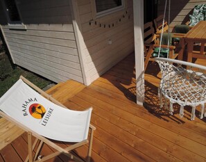 A wooden deck with a white lounge chair labeled "BAMA LEISURE" and a macrame chair. - Holiday Home Kolczewo Near Lake and Golf (gmina Wolin)