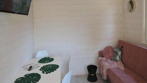 Ein gemütliches Zimmer mit einem weißen Tisch, einem rosa Sofa und einer Deckenleuchte.