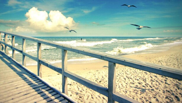 A beach with a wooden walkway and a railing overlooking the ocean. - Spacious Holiday Home With Private Garden (Mielno)