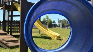 A playground with a blue slide and a yellow slide.