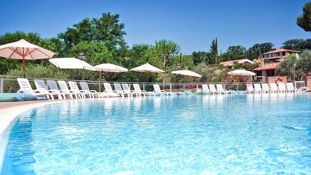 Une piscine aux eaux cristallines, dotée de chaises longues et de parasols.
