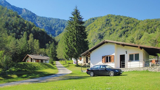A rural setting with a house and a car parked in front. - Apartment Santa Lucia in Bezecca (Ledro)