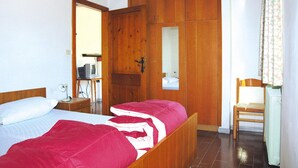 A bedroom with two beds, a wooden wardrobe, a desk with a computer, and a chair. - Apartment Santa Lucia in Bezecca (Ledro)
