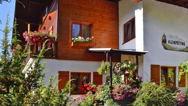 A wooden chalet with a balcony, a white exterior wall, and a sign reading "Kleinpötting". - Apartment in Huttau Near Ski Amade Slopes (Huettau)