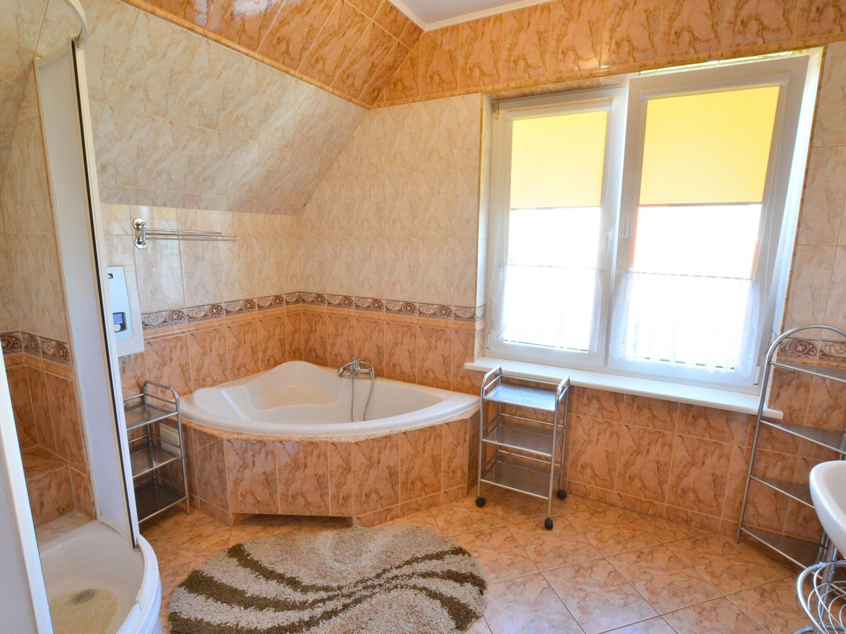 A bathroom with a freestanding bathtub, a window, and a shower area.