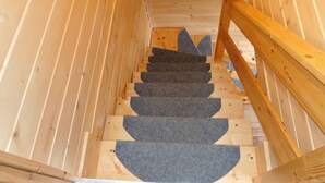 A wooden staircase with a handrail, leading upwards. - Family Resort in Niechorze Near Lighthouse (Rewal)