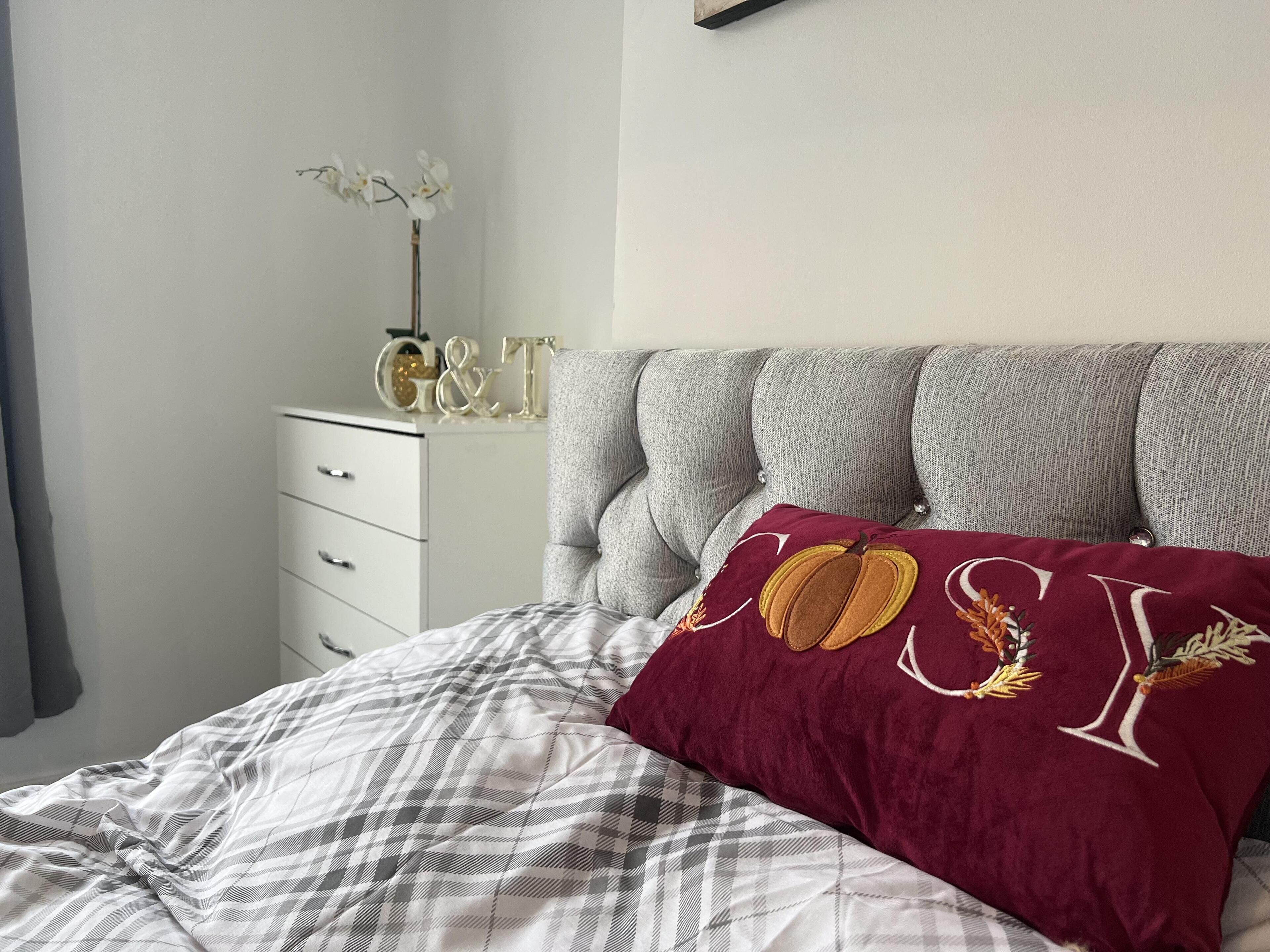 A bedroom with a bed, a dresser, and a decorative item on the dresser.