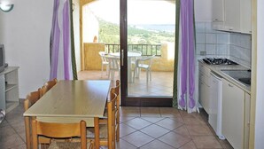 Eine Küche mit Essbereich, ein Balkon mit Stühlen und Blick auf die Landschaft.