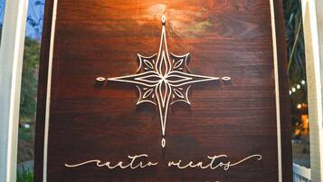A wooden plaque with a compass design and the text "ciento minutos" and a phone number.