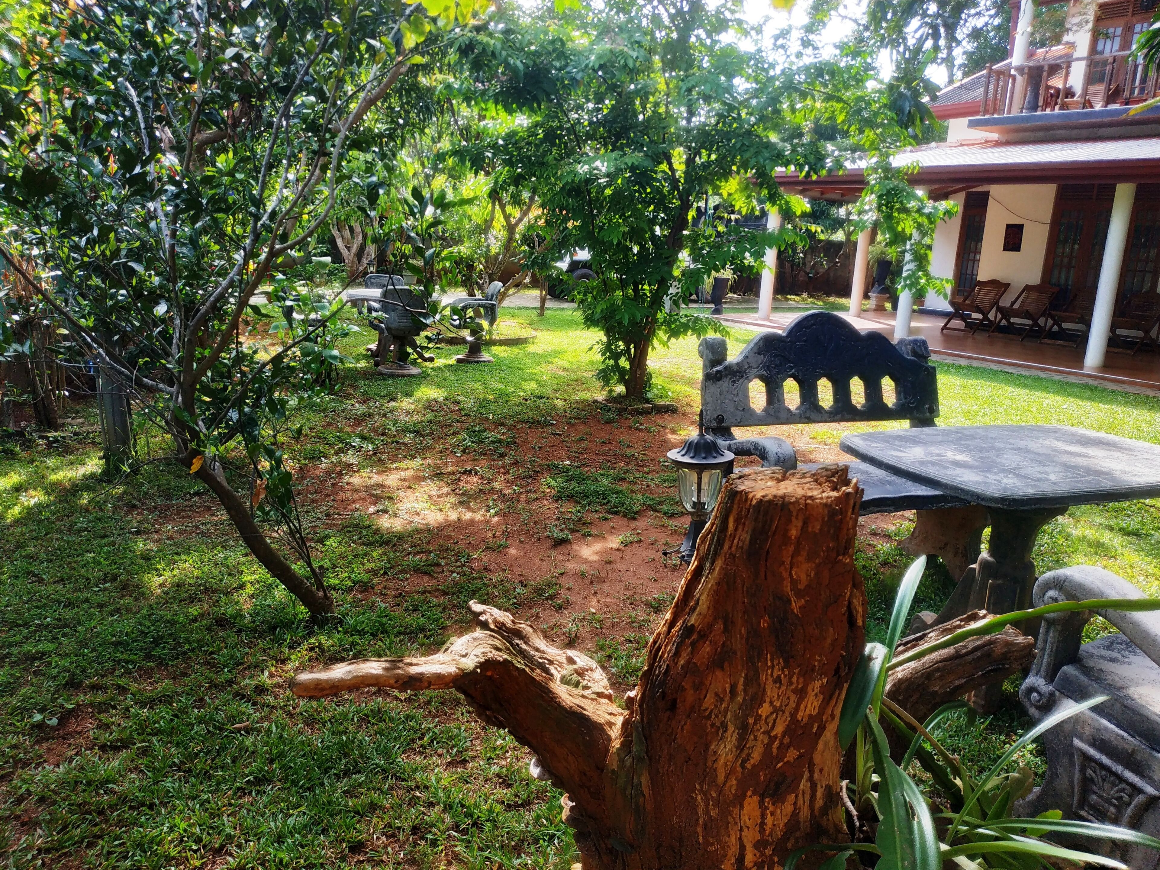 A garden area with a wooden bench, a table, and a lamp post.