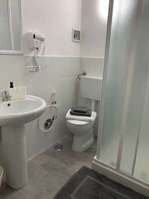 A bathroom with a white sink, a toilet, and a shower area. - B&B Sole e Luna (Rome)