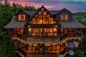A log cabin with multiple levels, a balcony, and a hot tub. - Luxury Cabin w/View! Sleeps 22, Movie Rm, Game Rm! (Gatlinburg)
