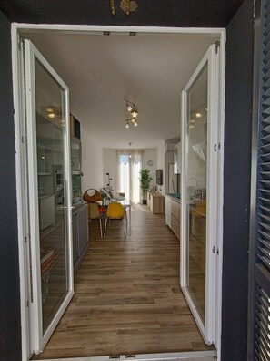 A narrow hallway with a dining area at the end, featuring a table and chairs. - Il Polpoleo apt in Portoazzurro,400mt Dalla Spiaggia, 900mt dal Centro,wifi (Porto Azzurro)