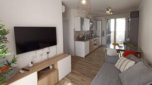 A modern living room with a flat-screen TV, a wooden entertainment unit, a grey sofa, and a kitchen in the background. - Il Polpoleo apt in Portoazzurro,400mt Dalla Spiaggia, 900mt dal Centro,wifi (Porto Azzurro)